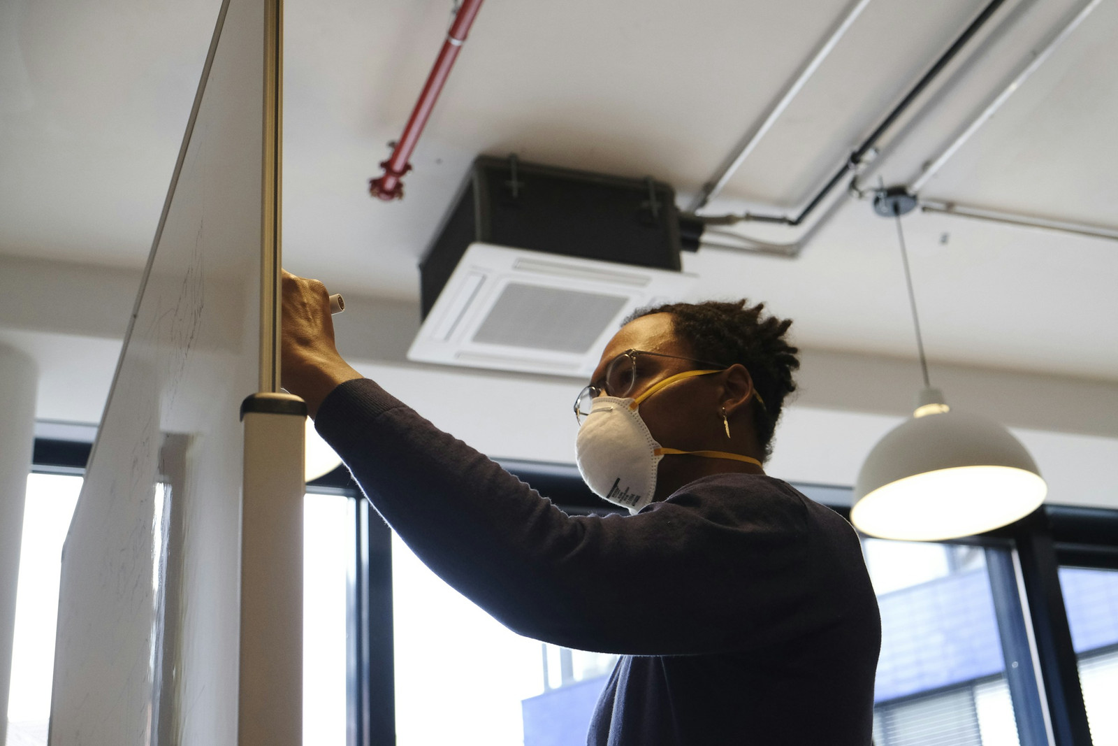 A technician servicing a ceiling-cassette unit